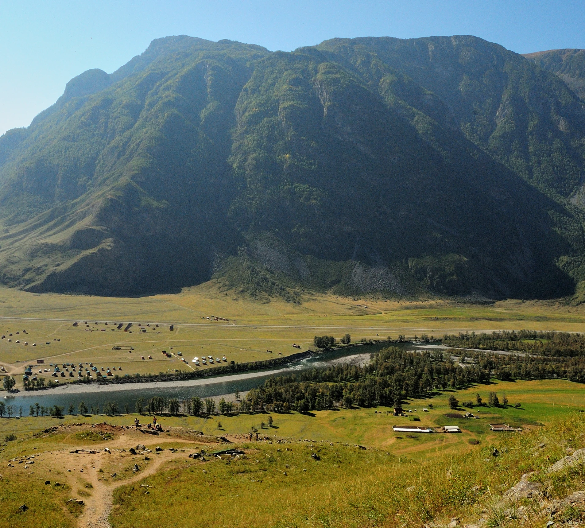 Mountain landscape with river and fields.