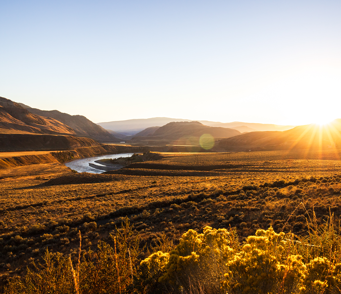 Sunset over winding river and hills